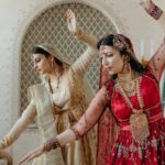 Rituals - Woman in Red Dress Standing Beside Woman in White Dress