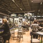 Exhibitions - People Inside a Cafe With Tables and Chairs