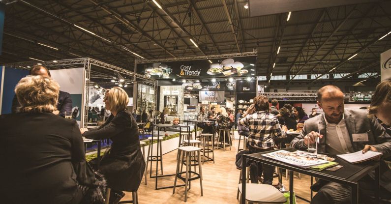 Exhibitions - People Inside a Cafe With Tables and Chairs