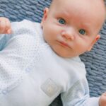 Beauty - Baby in White Onesie Lying on Grey Textile