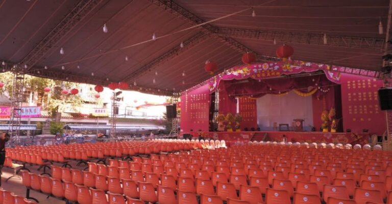 Venues - A large tent with orange chairs and red carpet